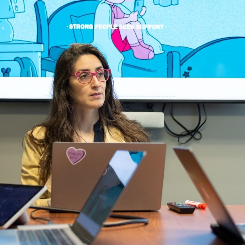 Dr. Shelly Ben-David at a table with laptops open.